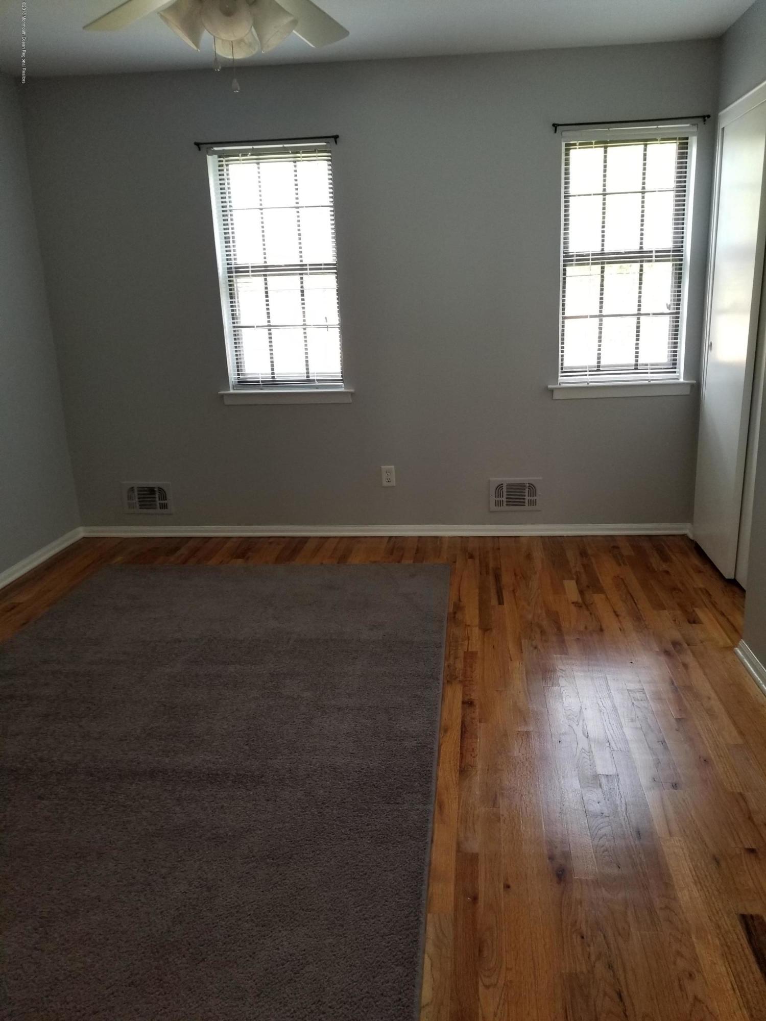 321 Spring Street, Unit 21 Red Bank, NJ 07701 - Photo 9 of 11 an empty room with wooden floor and windows