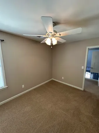a view of an empty room with a chandelier fan