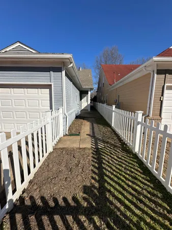 a view of a brick house with wooden fence
