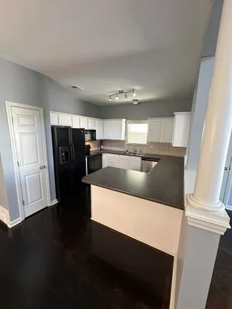 a kitchen with stainless steel appliances a refrigerator and wooden floor