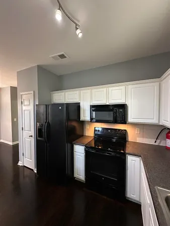 a kitchen with a refrigerator and a stove top oven
