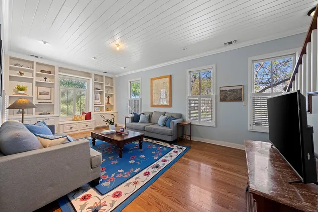 a living room with furniture fireplace and a large window