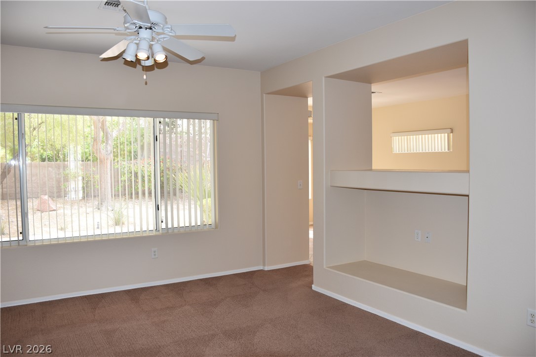 1680 Fieldbrook Street Henderson, NV 89052 - Photo 15 of 32 An open doorway and a built-in media niche connect this carpeted living room to adjacent spaces.