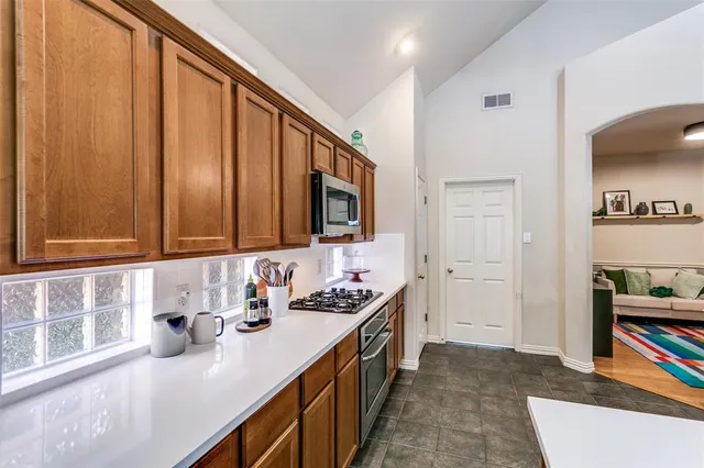a kitchen with stainless steel appliances a sink stove and cabinets