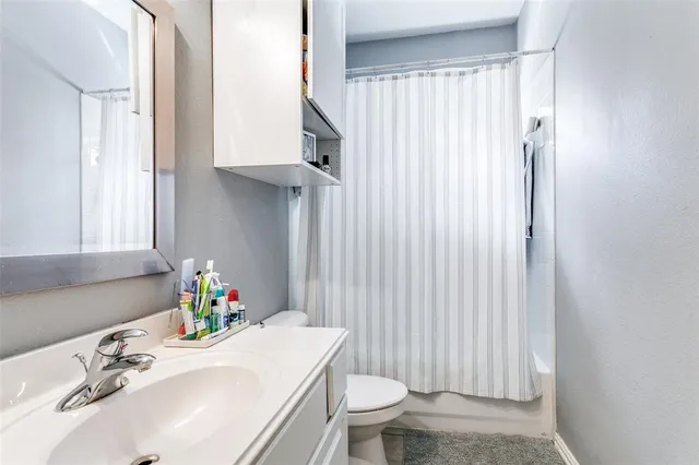 a bathroom with a sink toilet and window