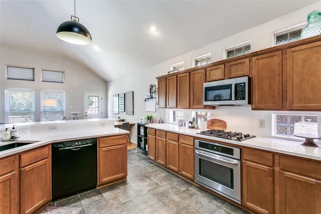 a kitchen with stainless steel appliances granite countertop a sink and stove top oven