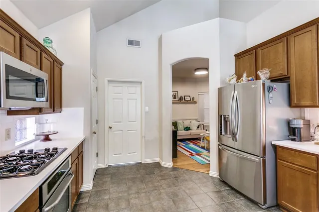 a kitchen with stainless steel appliances granite countertop a refrigerator stove and sink