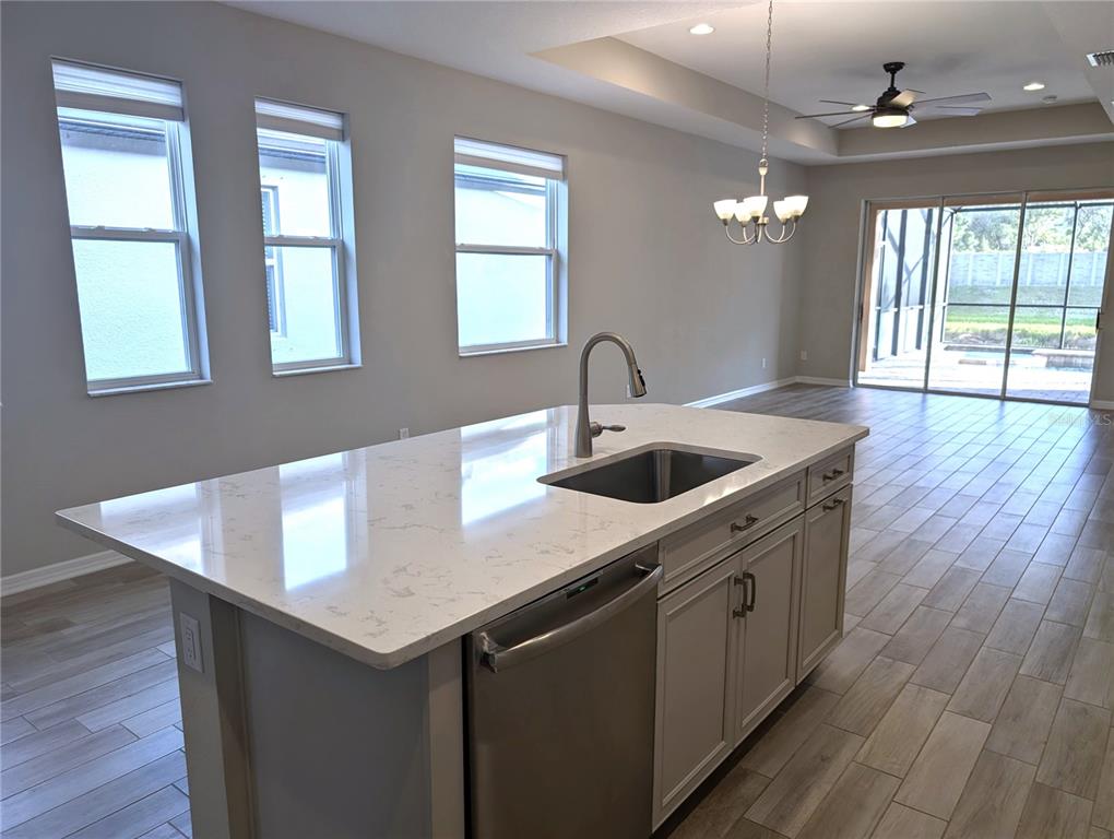 8545 Cache Drive Sarasota, FL 34240 - Photo 11 of 38 a kitchen with a sink dishwasher a dining table and chairs with wooden floor