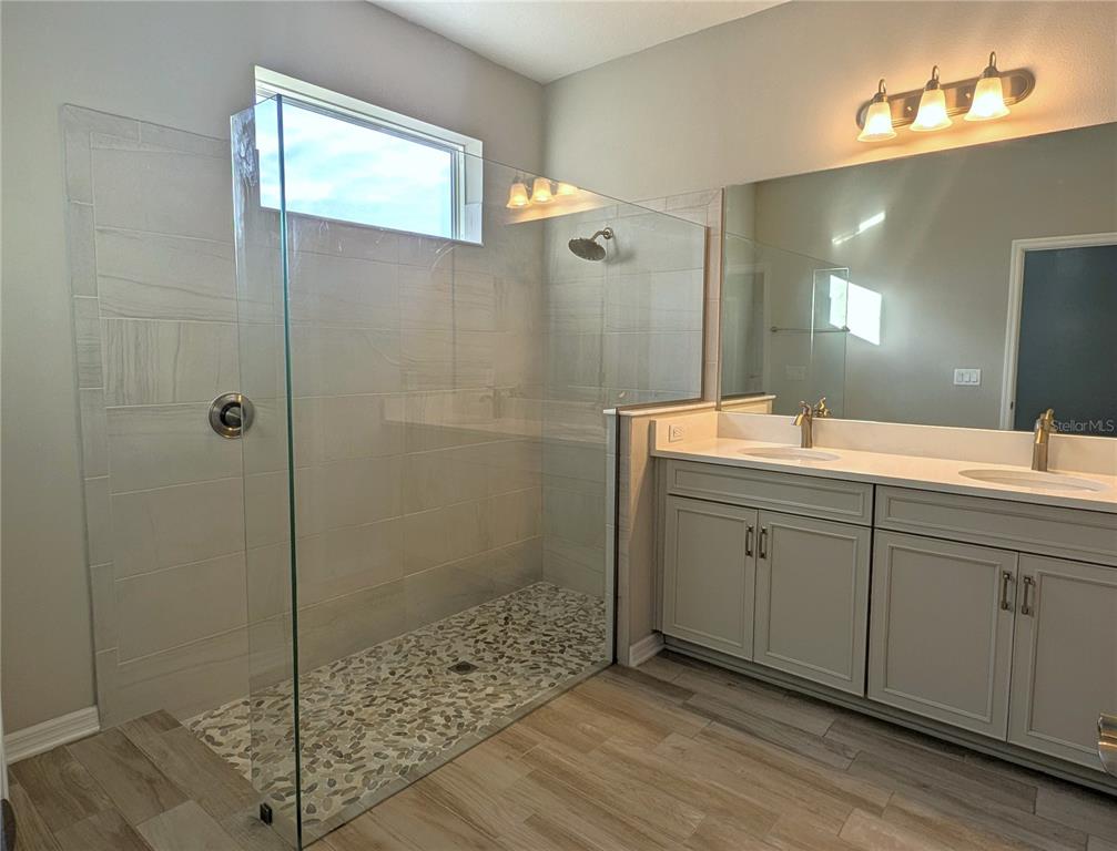8545 Cache Drive Sarasota, FL 34240 - Photo 15 of 38 a spacious bathroom with a shower a sink and mirror