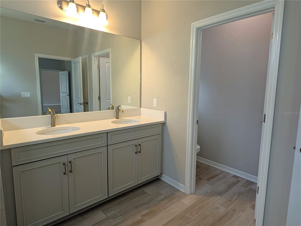 8545 Cache Drive Sarasota, FL 34240 - Photo 16 of 38 a bathroom with a double vanity sink and mirror