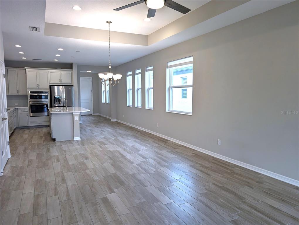 8545 Cache Drive Sarasota, FL 34240 - Photo 5 of 38 an empty room with wooden floor and windows