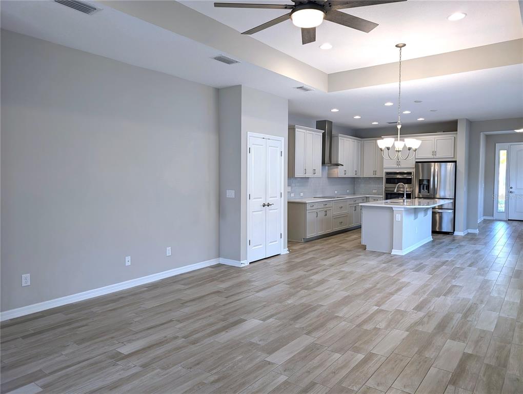 8545 Cache Drive Sarasota, FL 34240 - Photo 6 of 38 an empty room with wooden floor and kitchen view