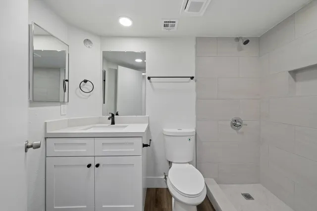 a bathroom with a sink toilet a mirror and shower