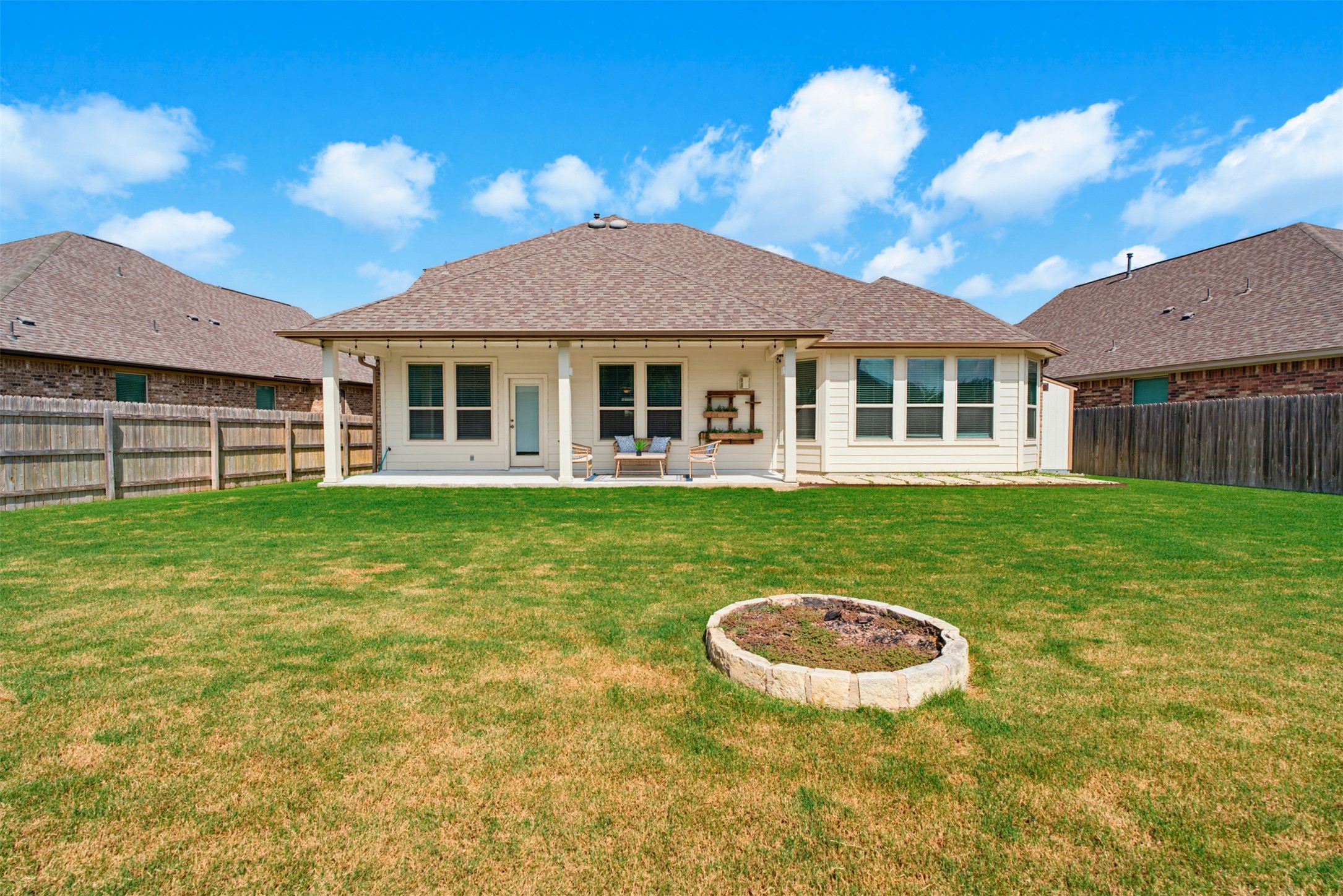 12613 Twisted Root Drive Manchaca, TX 78652 - Photo 18 of 33 Backyard with a fire pit offers a perfect outdoor gathering space and a covered patio for relaxation.