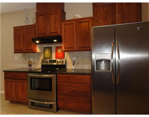 a kitchen with stainless steel appliances granite countertop a stove and a refrigerator