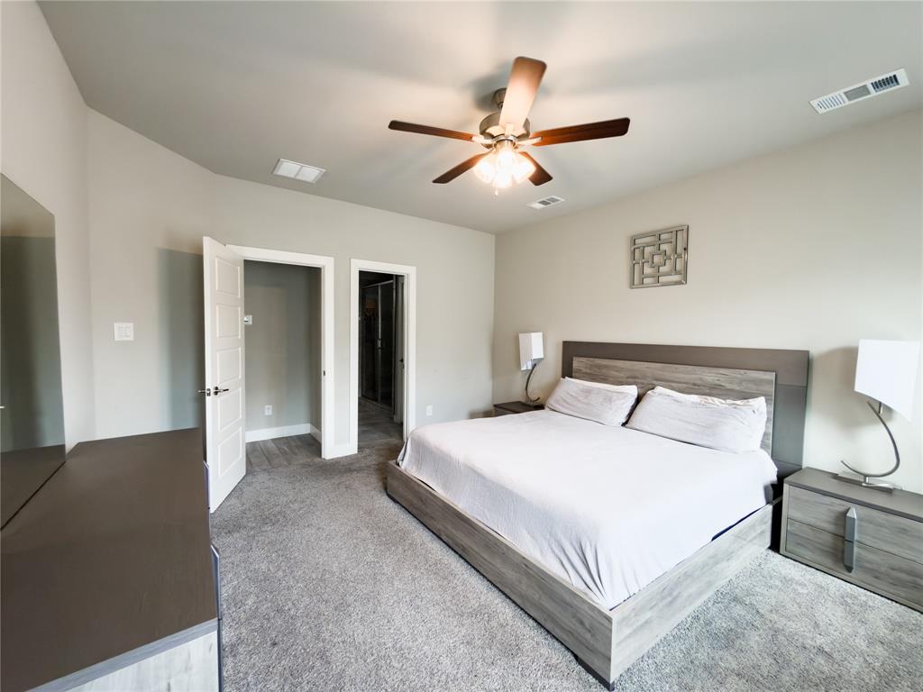 113 Nathan Drive Princeton, TX 75407 - Photo 14 of 40 a bedroom with a bed and a chandelier