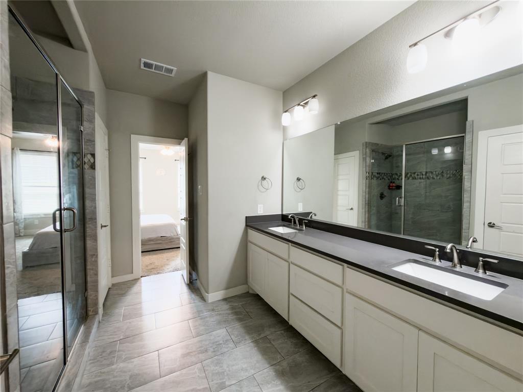 113 Nathan Drive Princeton, TX 75407 - Photo 15 of 40 a spacious bathroom with a double vanity sink a mirror and a shower