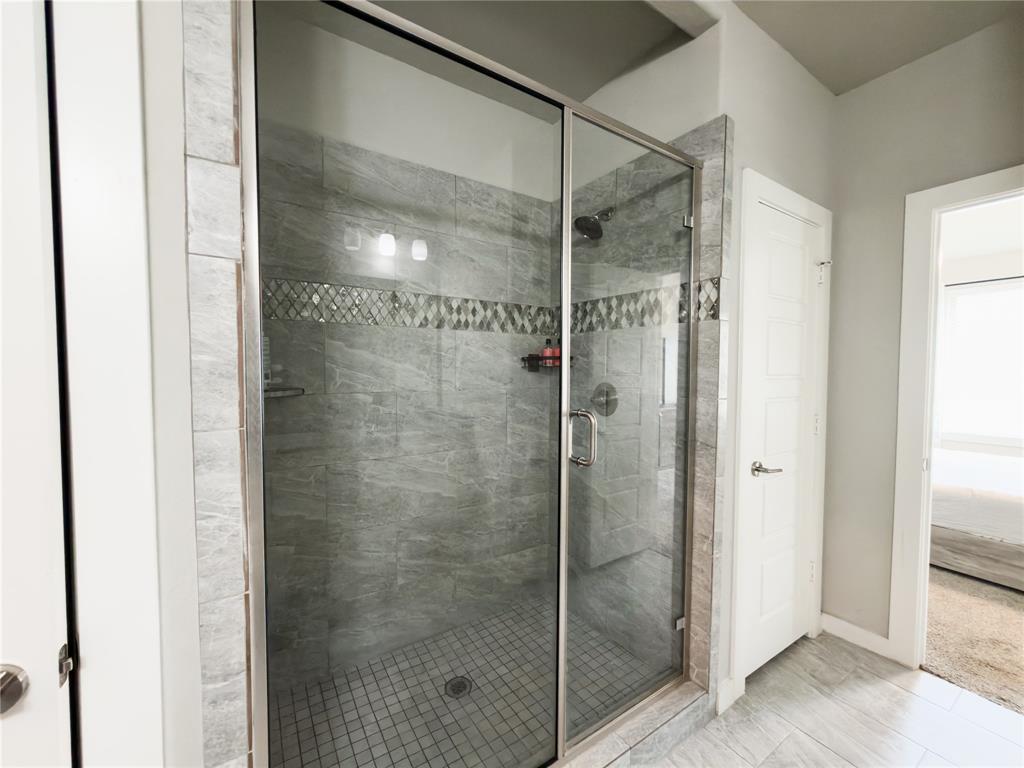 113 Nathan Drive Princeton, TX 75407 - Photo 17 of 40 a bathroom with a glass shower door
