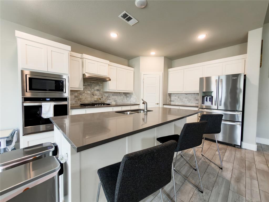113 Nathan Drive Princeton, TX 75407 - Photo 8 of 40 a large kitchen with kitchen island a large counter top space appliances and cabinets