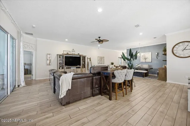 a living room with furniture a flat screen tv and a refrigerator