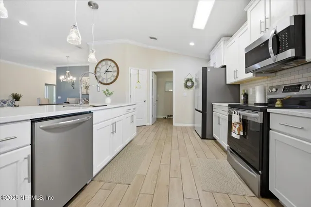 a large white kitchen with stainless steel appliances
