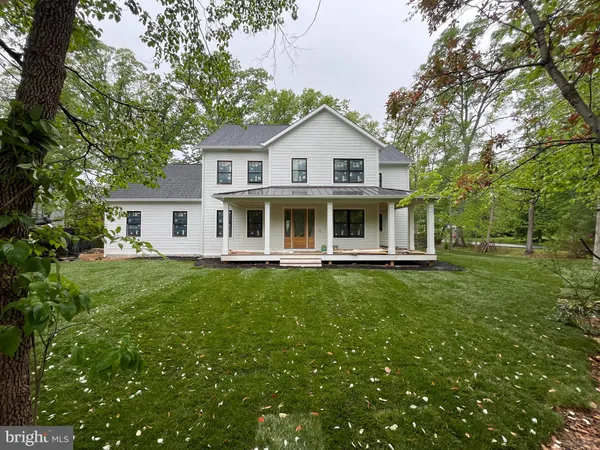 a view of a white house with a big yard and large trees