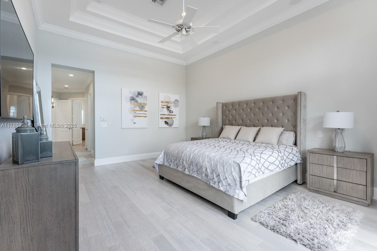 17937 Villa Club Way Boca Raton, FL 33496 - Photo 21 of 41 a bedroom with a large bed and a chandelier