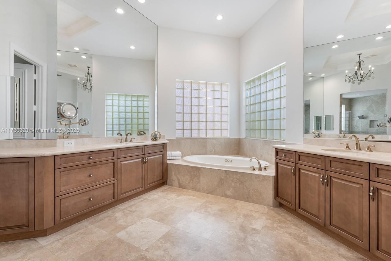 17937 Villa Club Way Boca Raton, FL 33496 - Photo 23 of 41 a spacious bathroom with a double vanity sink a large mirror and a bathtub