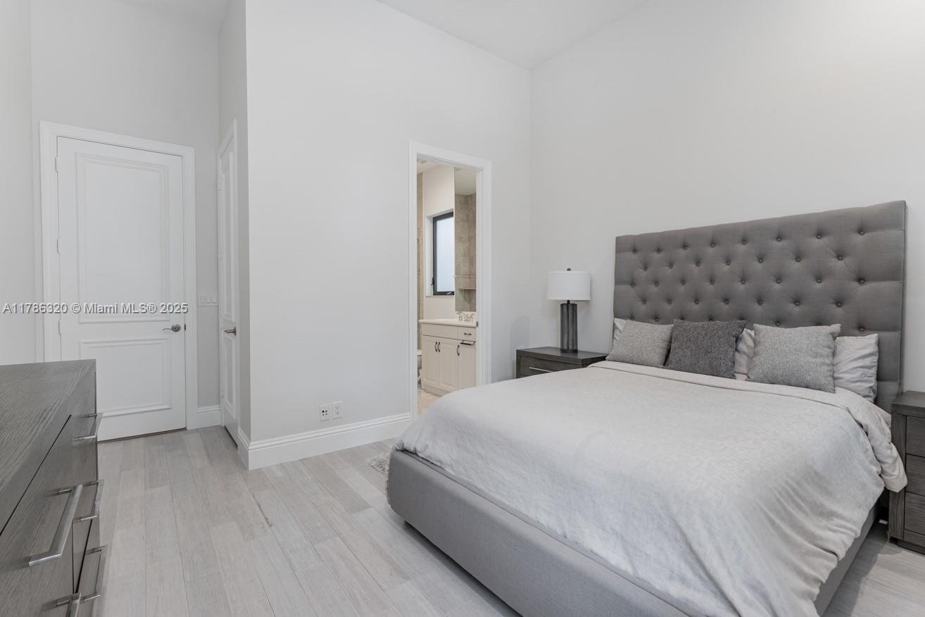 17937 Villa Club Way Boca Raton, FL 33496 - Photo 29 of 41 a bedroom with a bed and wooden floor