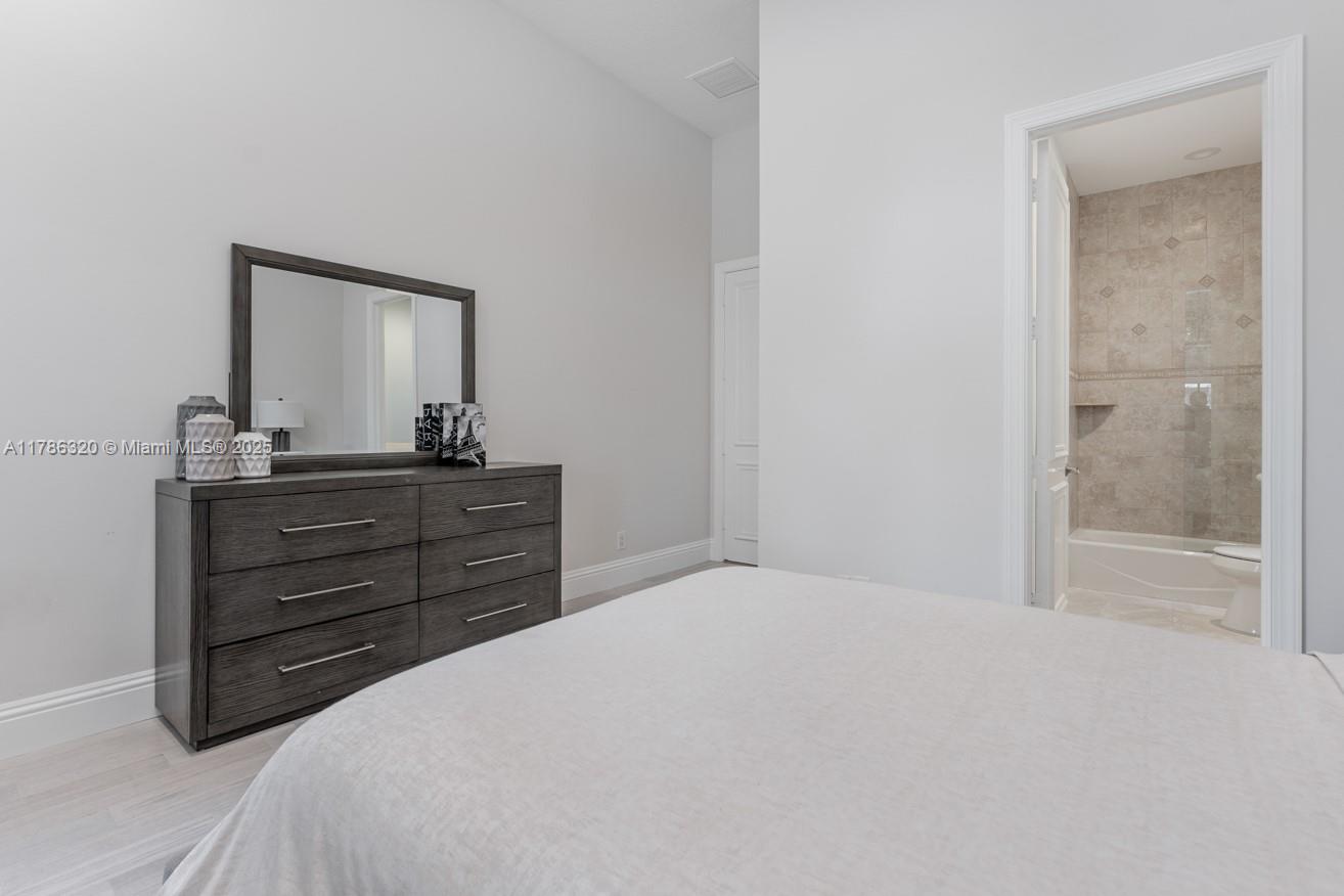 17937 Villa Club Way Boca Raton, FL 33496 - Photo 30 of 41 a bedroom with a bed and a mirror on dresser