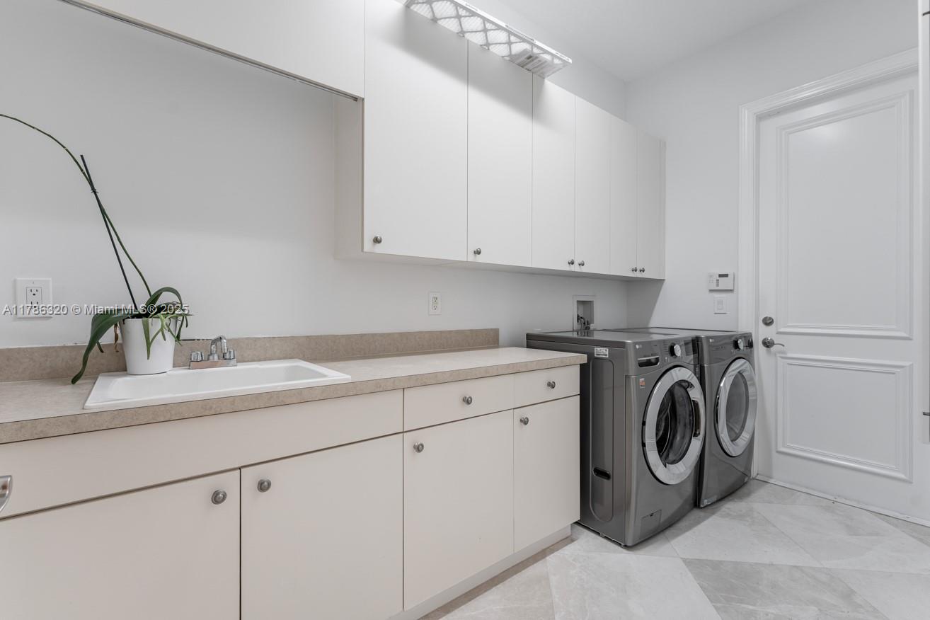 17937 Villa Club Way Boca Raton, FL 33496 - Photo 35 of 41 a utility room with cabinets washer and dryer