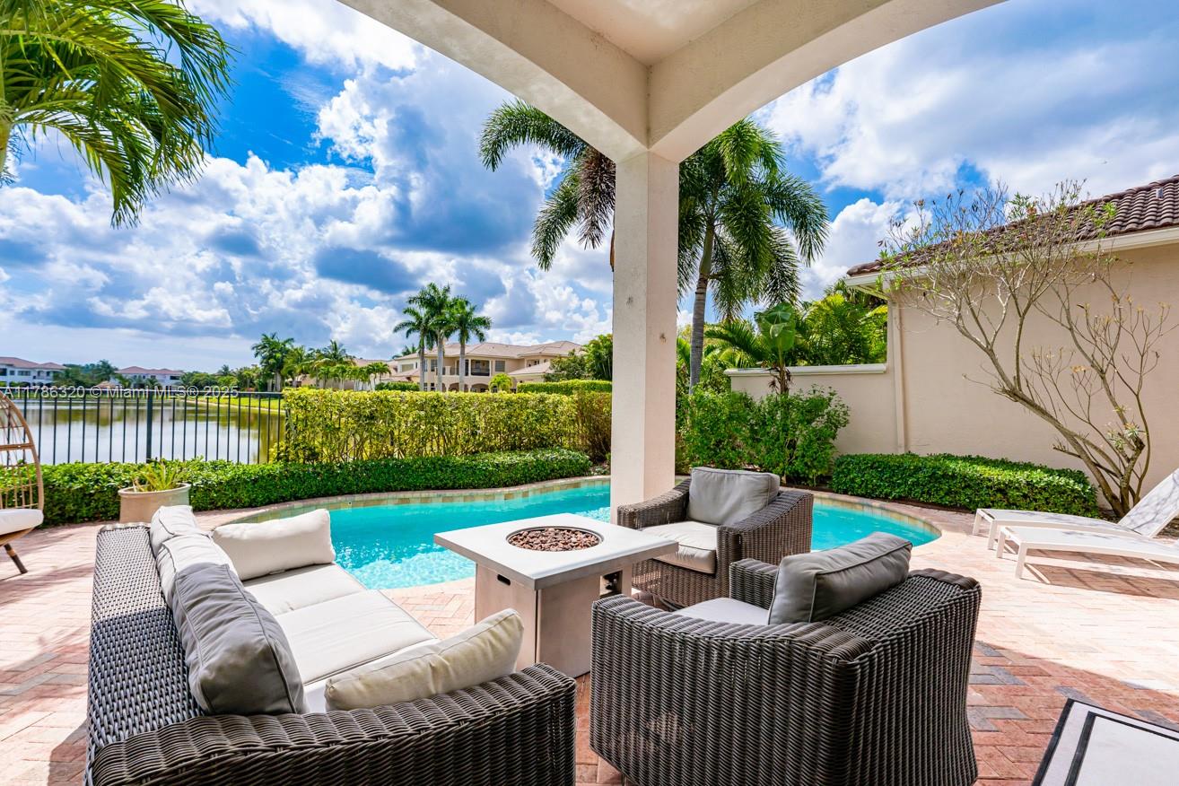 17937 Villa Club Way Boca Raton, FL 33496 - Photo 38 of 41 a view of a patio with couches chairs potted plants and a palm tree