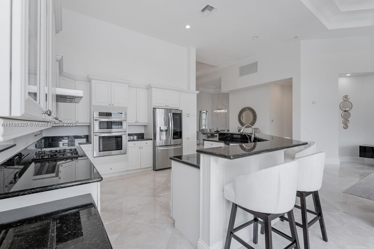 17937 Villa Club Way Boca Raton, FL 33496 - Photo 10 of 41 a kitchen with stainless steel appliances a stove a sink and a refrigerator