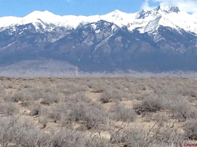a view of a dry yard with mountains in the background