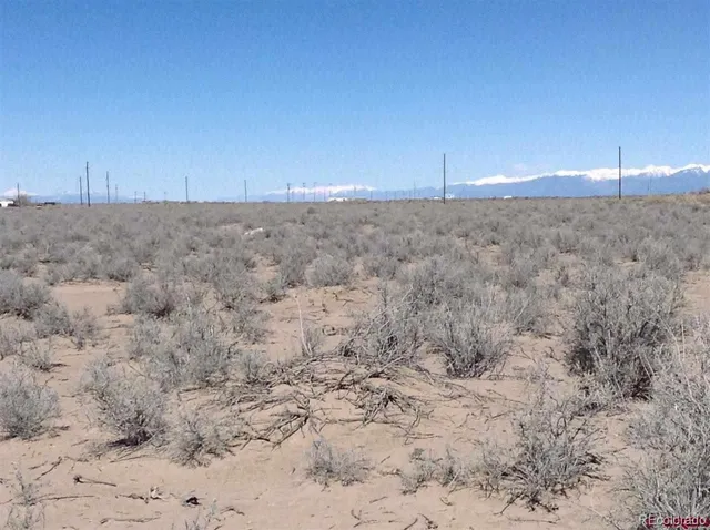 a view of a dry field with an ocean view