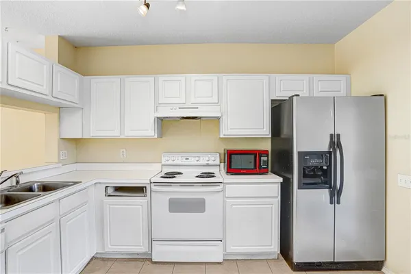 a kitchen with stainless steel appliances a refrigerator sink and cabinets