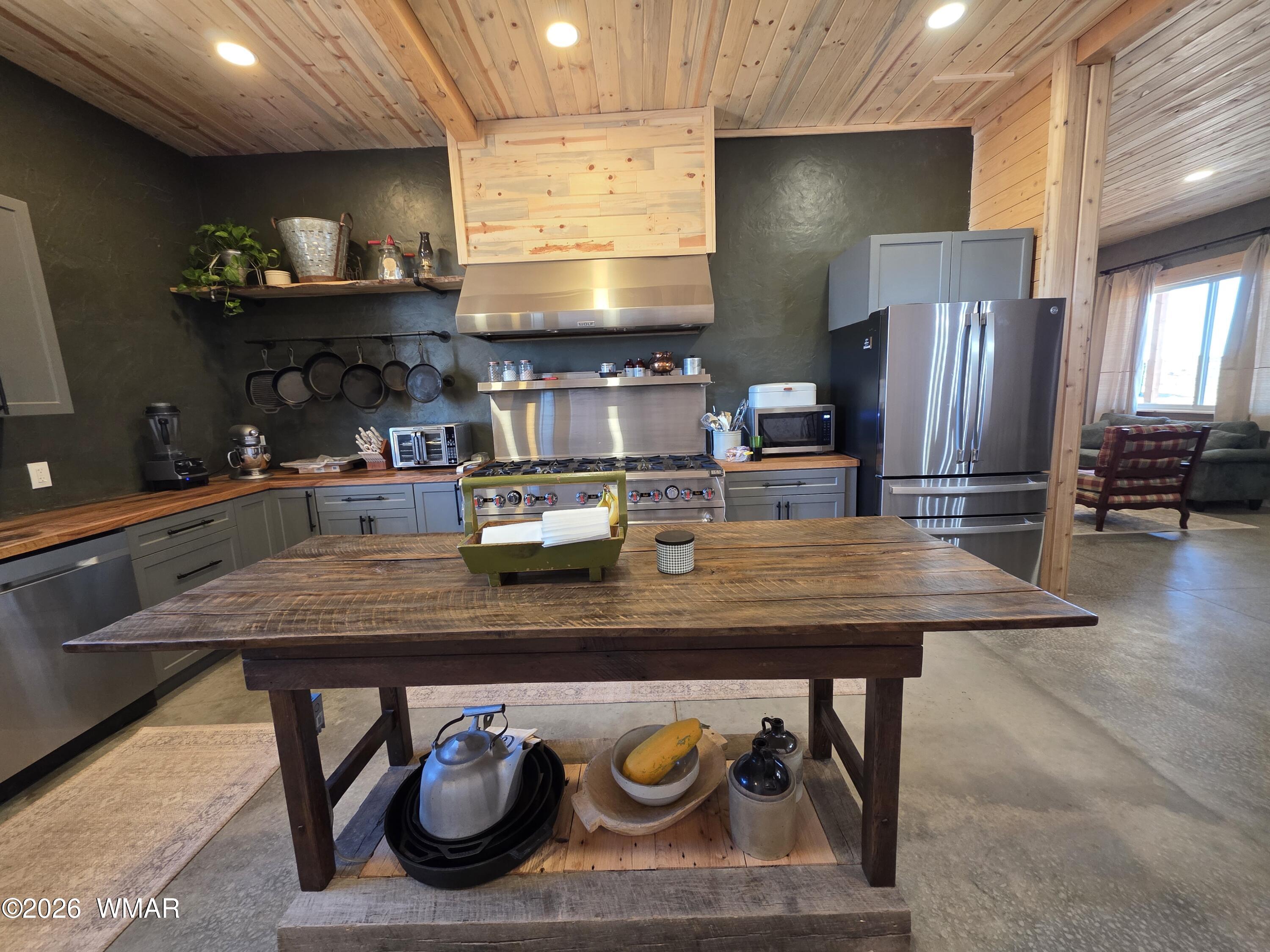 5057 Churchill Road Snowflake, AZ 85937 - Photo 20 of 115 a kitchen with stainless steel appliances granite countertop a table chairs in it and wooden floors