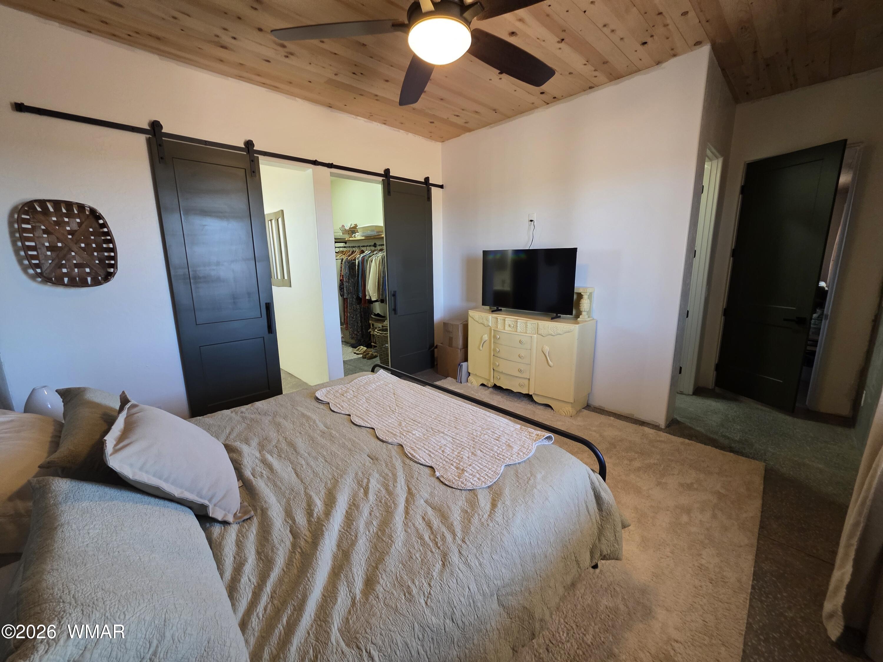 5057 Churchill Road Snowflake, AZ 85937 - Photo 40 of 115 a bedroom with a bed and a flat tv screen on wall