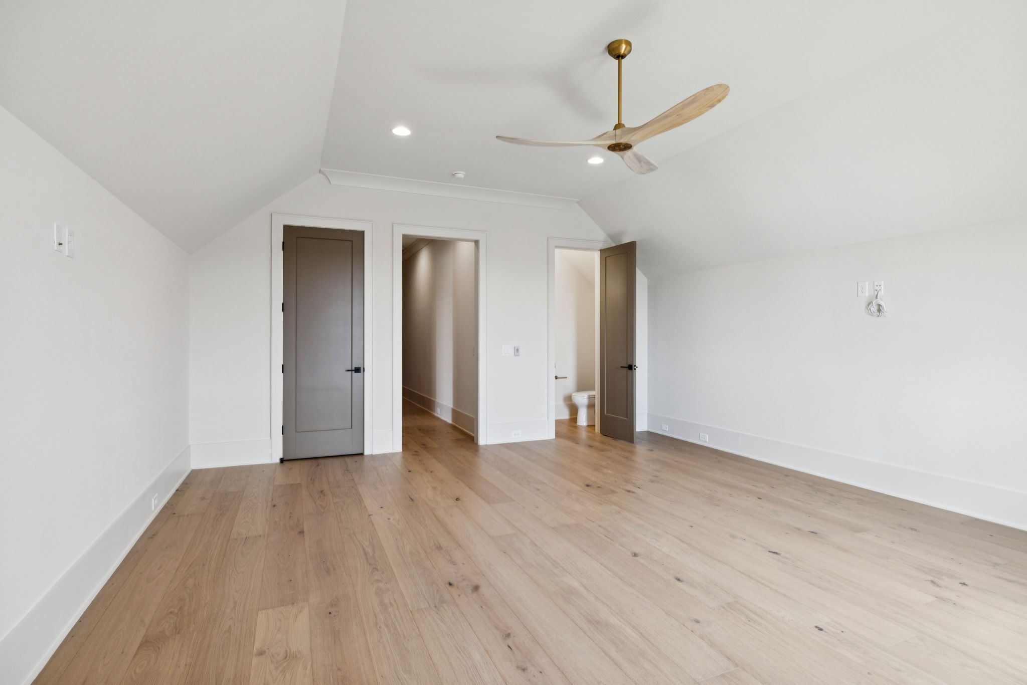 8101 Heirloom Boulevard College Grove, TN 37046 - Photo 49 of 81 an empty room with wooden floor a ceiling fan and kitchen view