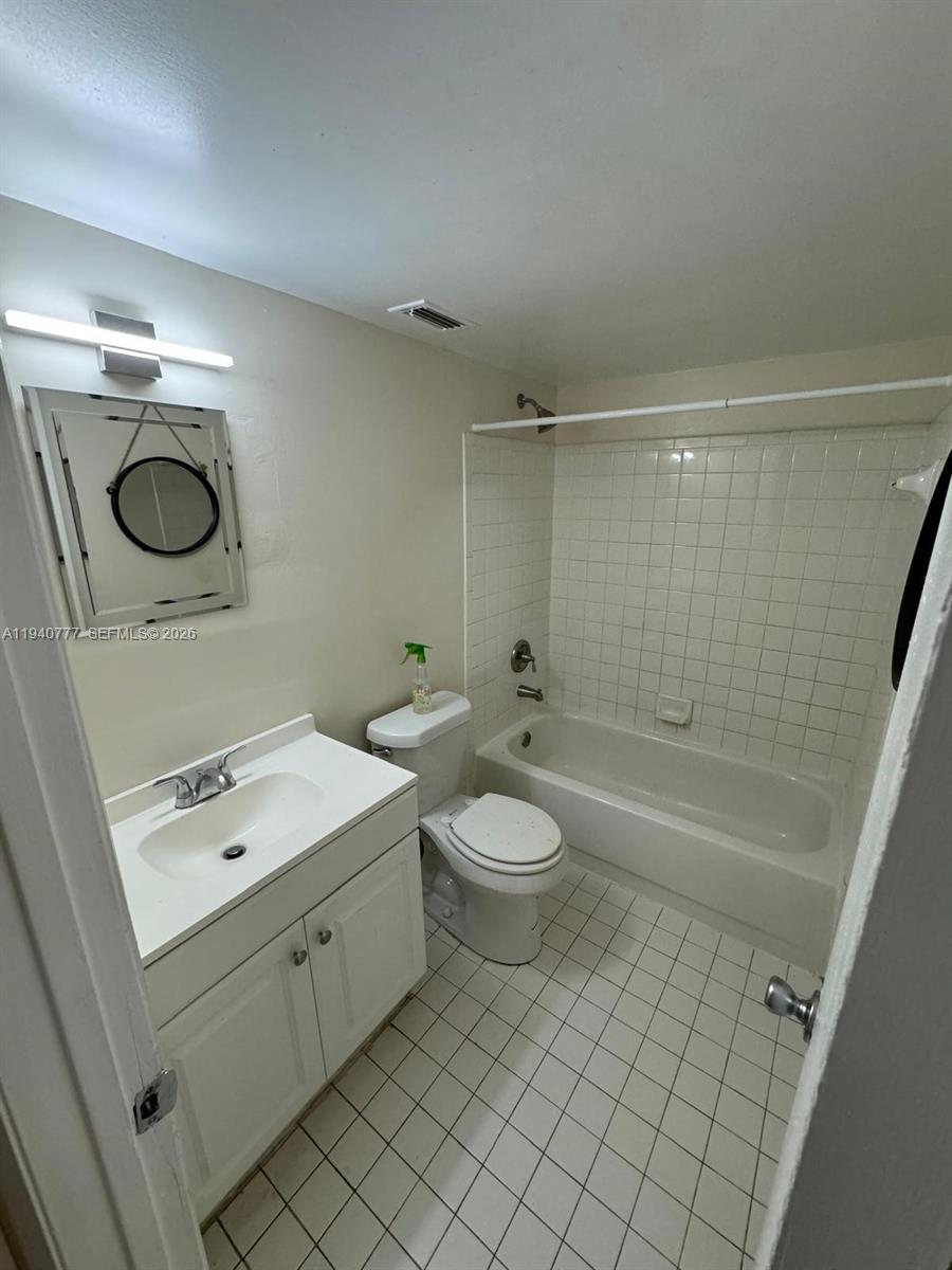 11307 Southwest 200th Street, Unit 310B Miami, FL 33157 - Photo 10 of 14 a bathroom with a sink a toilet and shower