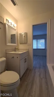 a bathroom with a toilet a sink and mirror