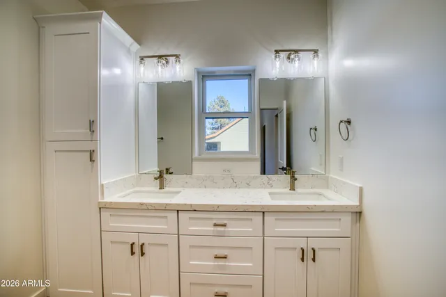 a bathroom with a double vanity sink and a mirror
