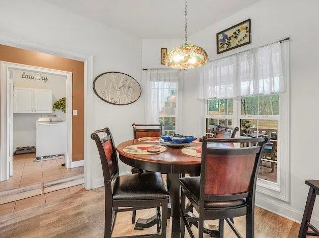 a view of a dining room with furniture a chandelier and wooden floor