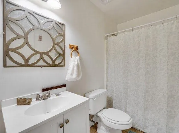 a bathroom with a sink mirror vanity and toilet
