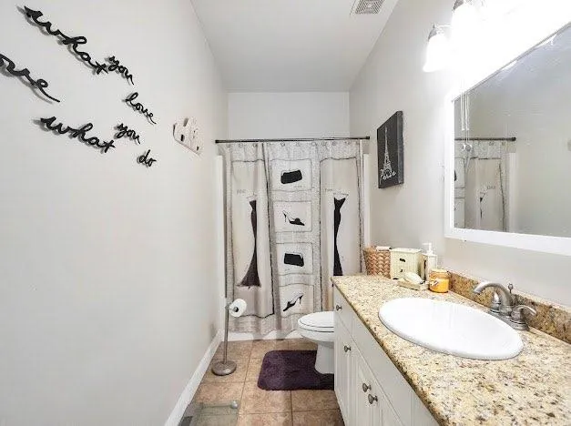 a bathroom with a granite countertop bathtub sink mirror and vanity