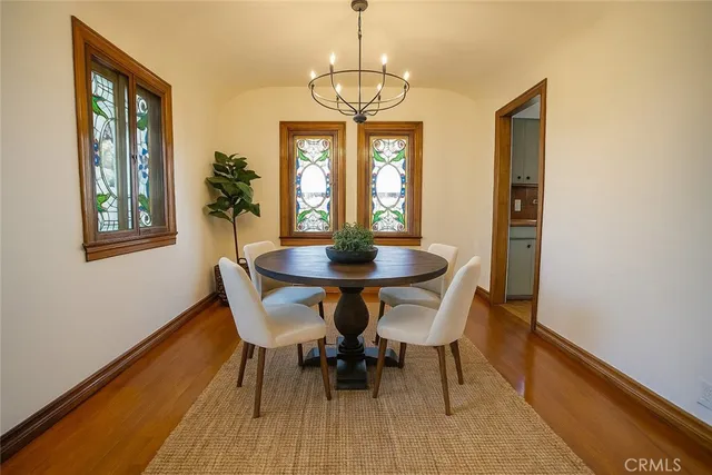 a dining room with furniture a chandelier and wooden floor