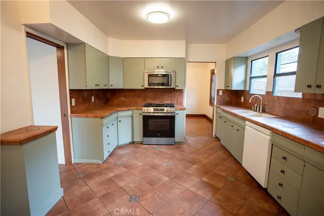 a kitchen with stainless steel appliances granite countertop a stove a sink and a refrigerator
