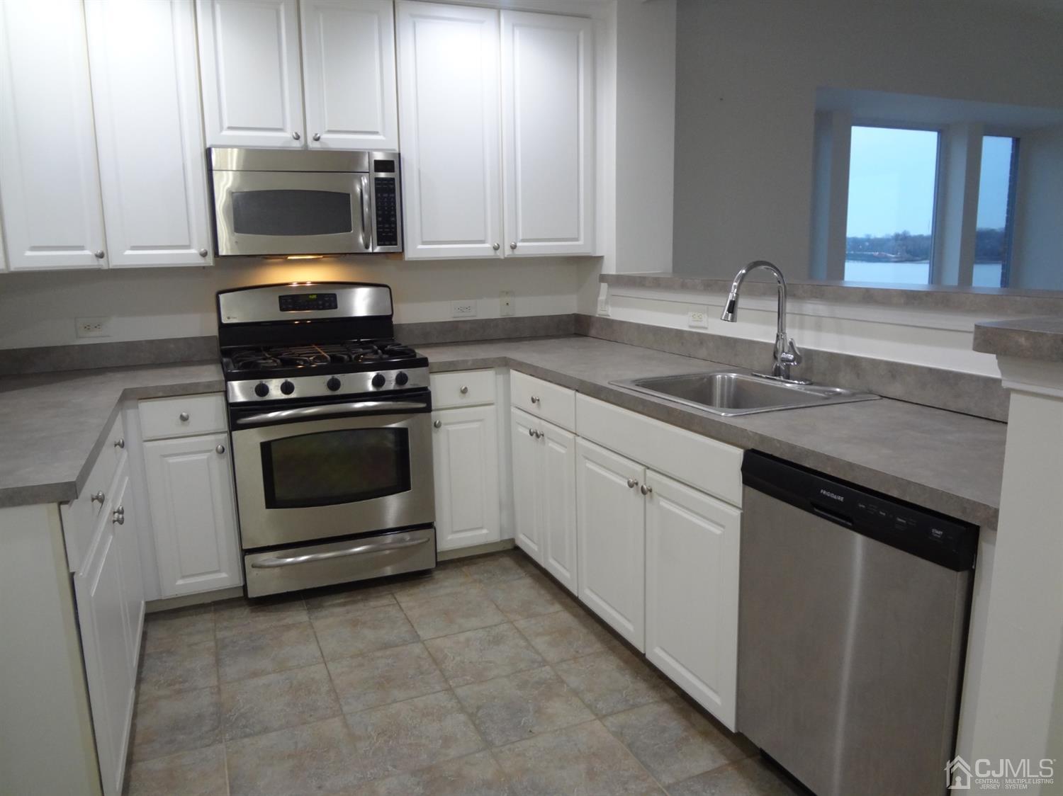 358 Rector Street, Unit 511 Perth Amboy, NJ 08861 - Photo 12 of 29 a kitchen with cabinets stainless steel appliances and a sink