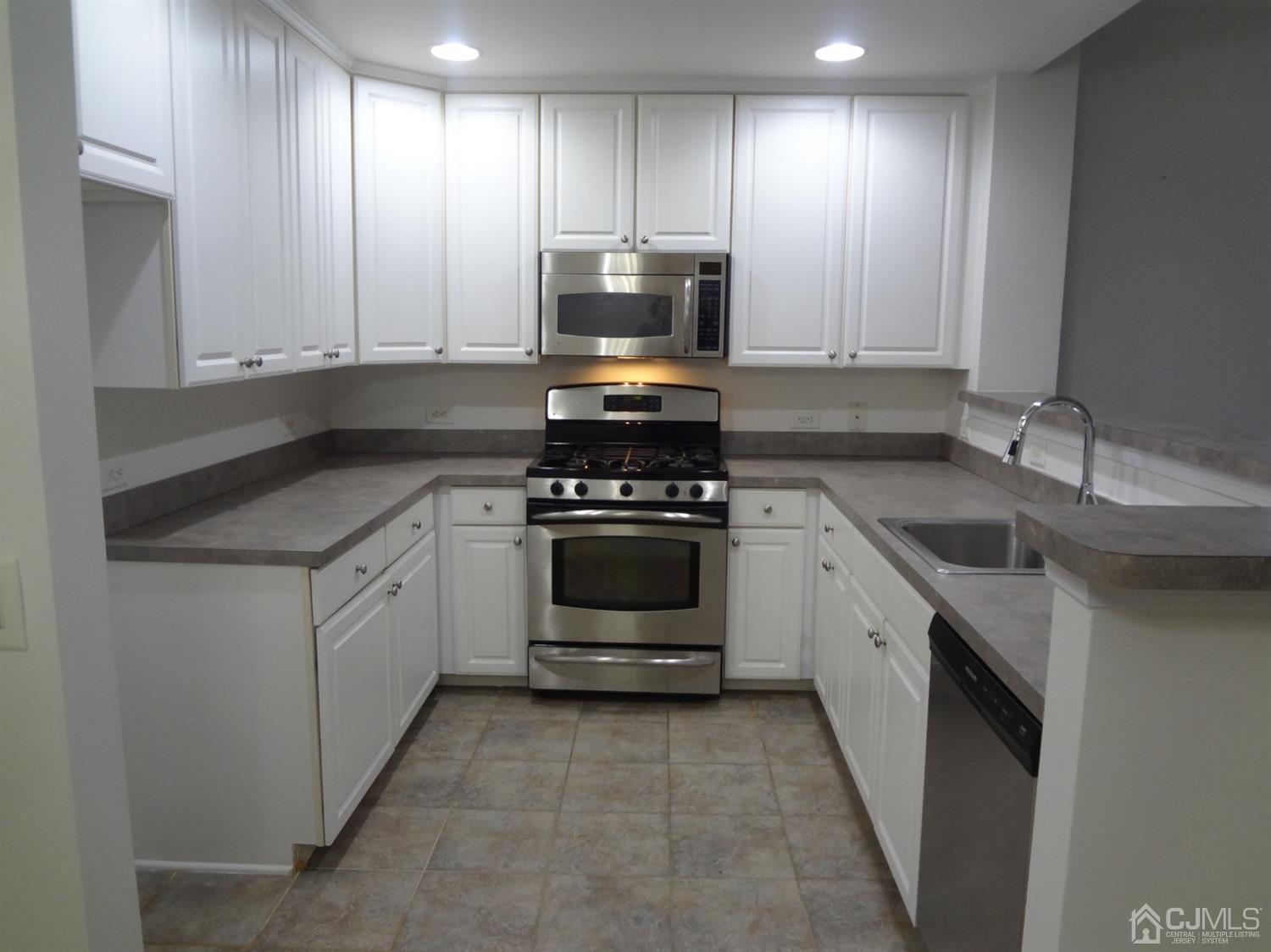 358 Rector Street, Unit 511 Perth Amboy, NJ 08861 - Photo 13 of 29 a kitchen with white cabinets and appliances