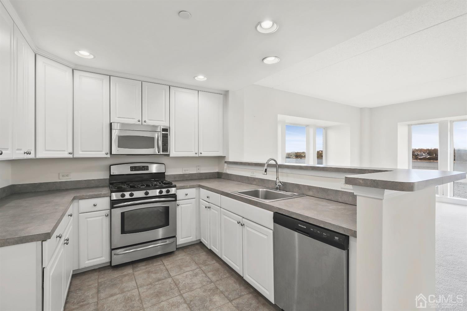 358 Rector Street, Unit 511 Perth Amboy, NJ 08861 - Photo 24 of 29 a kitchen with white cabinets stainless steel appliances and sink